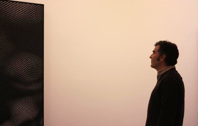 Alberto de Juan, galerista de Max Estrella, contempla una de las obras de Aitor Ortiz